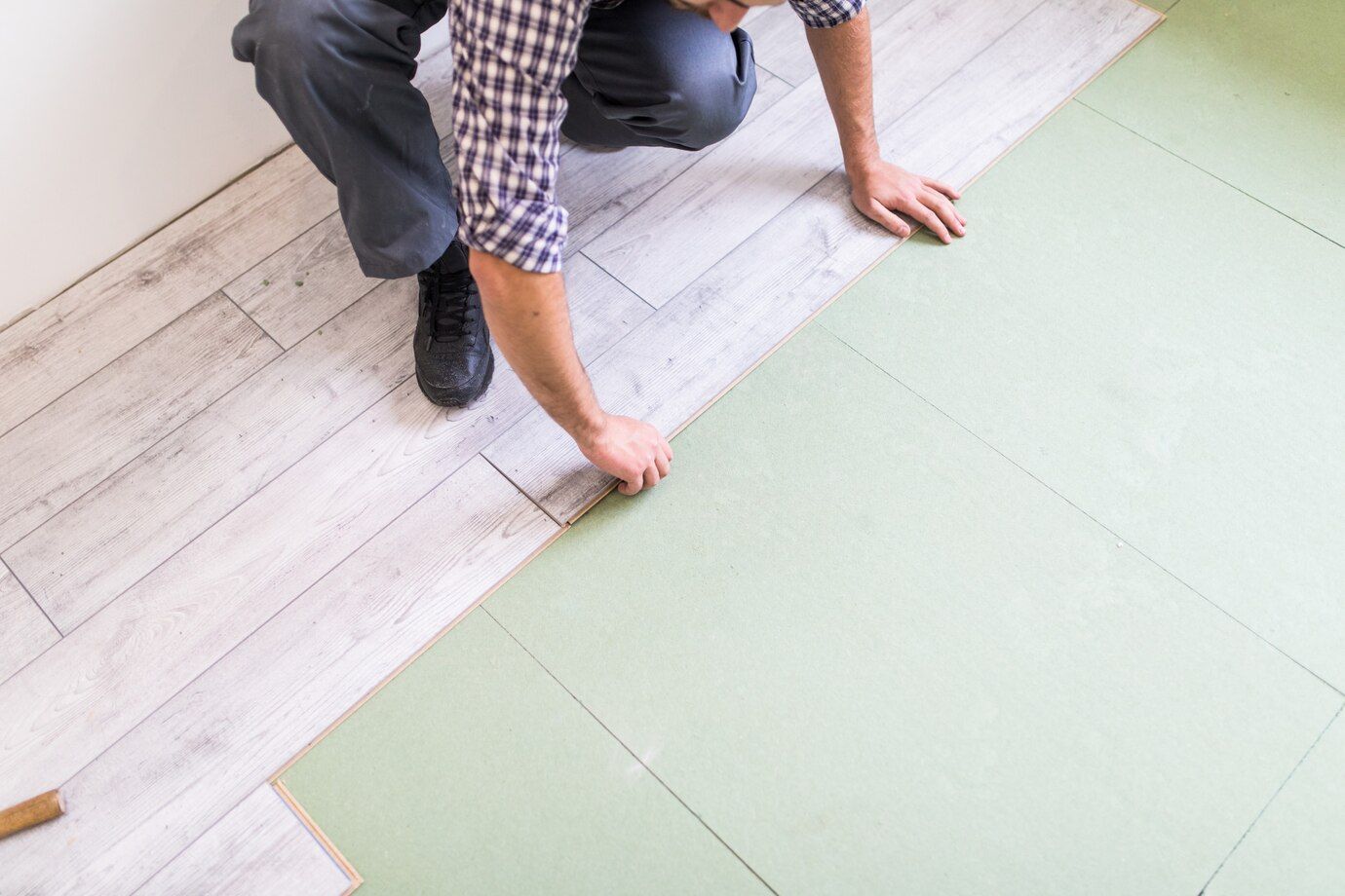 worker-processing-floor-with-bright-laminated-flooring-boards_231208-4213.jpg